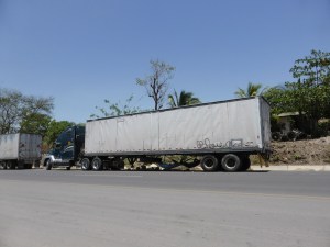 A classic border crossing scene, truckers chilling in hammocks under there trucks while their paper work gets processed.