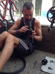 Bren rebuilding the wheel (outside the front of the bike shop) with new SON hub. Thanks